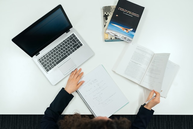 Qué documentos necesita una imprenta para imprimir tu libro correctamente Autor revisando pruebas de impresión junto a un portátil y muestras físicas de papel.